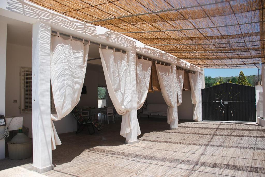 a covered porch with white curtains on a house at Casa tu Nonnu in Ugento