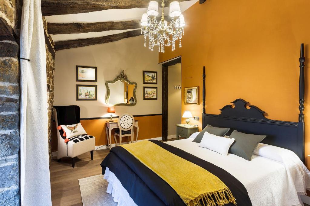 a bedroom with a large bed and a chandelier at Posada Casa Guadamillas 