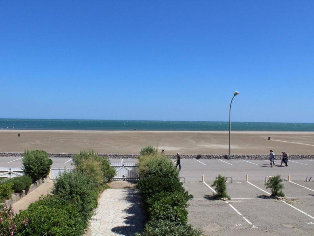 een parkeerplaats met een strand op de achtergrond bij Appartement Port-la-Nouvelle, 2 pièces, 5 personnes - FR-1-229C-495 in Port-la-Nouvelle