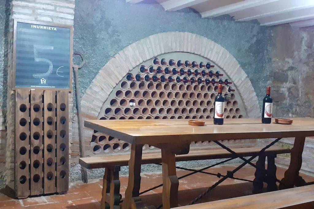 una mesa con 2 botellas de vino en una bodega en Casa SAN MIGUEL en Tarazona, en Tarazona de Aragón