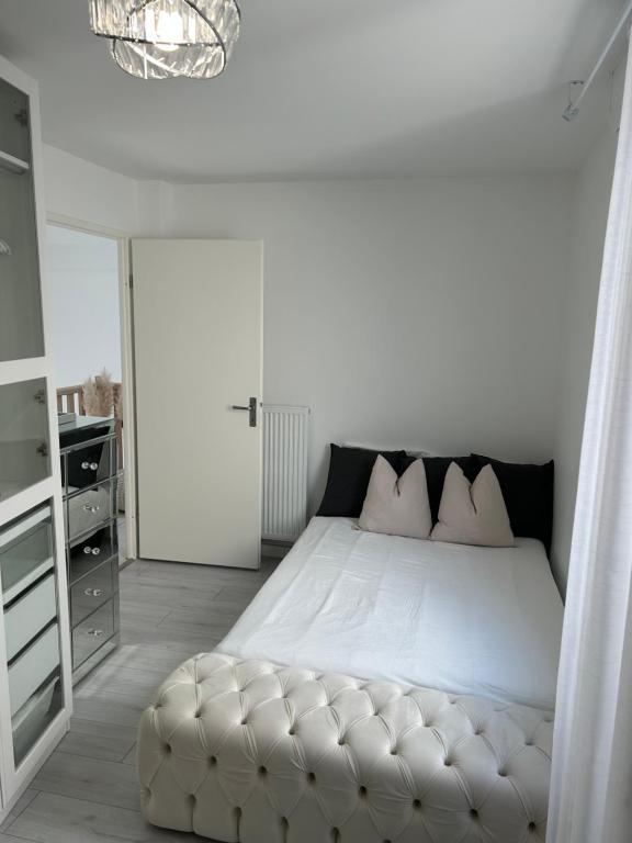 1 dormitorio con 1 cama blanca grande con reposapiés en Appart duplex 87m2 près d’Airbus, en Toulouse