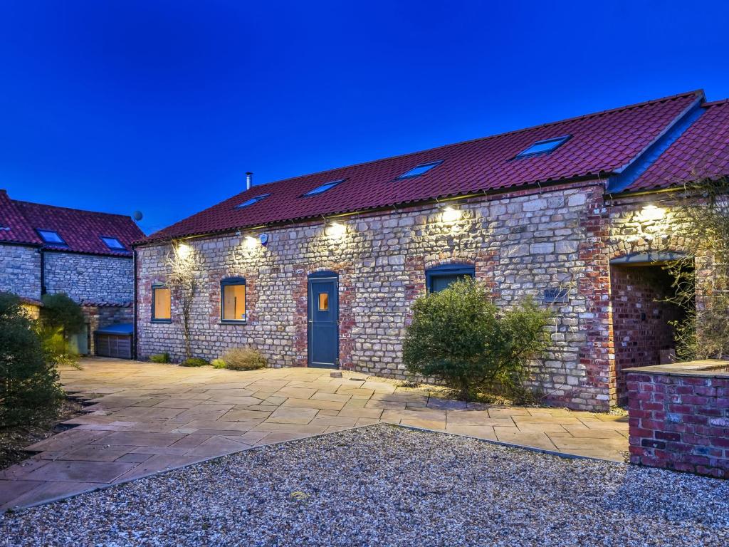 a brick building with a blue door and lights at Hayloft in Lincoln