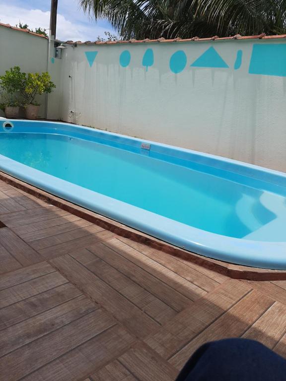 a large blue swimming pool next to a wall at Acordar com o cantar do passaro in Jabuticabal