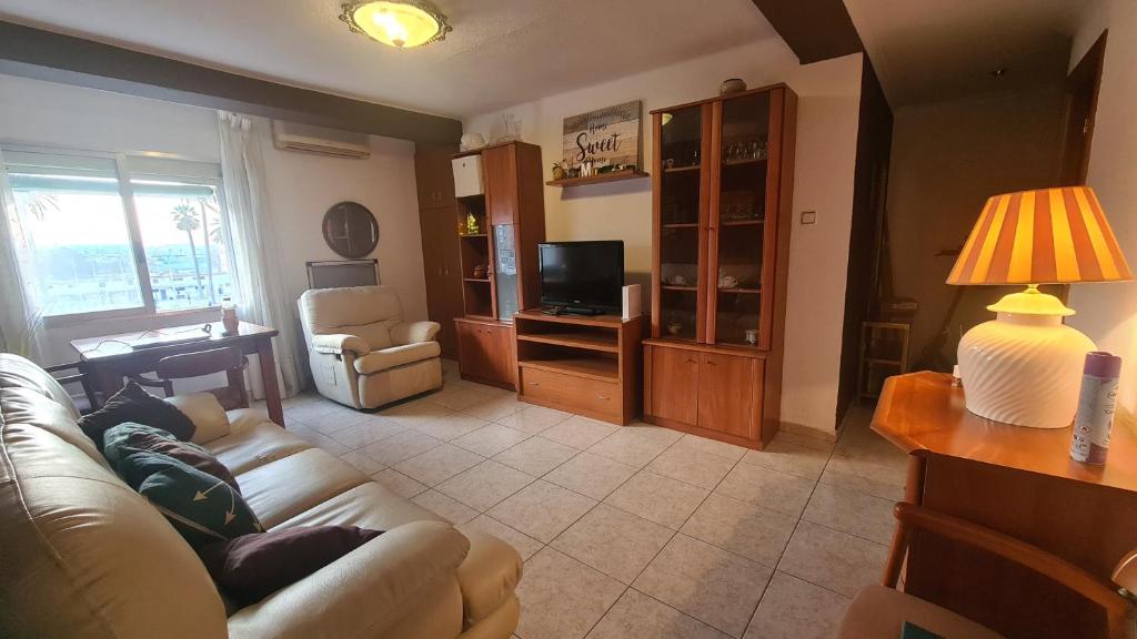 a living room with a couch and a television at Rooms on Malvarrosa beach in Valencia