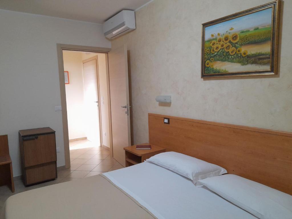 um quarto com duas camas e um quadro na parede em B&B Il Giardino di Zefiro em Gioiosa Marea