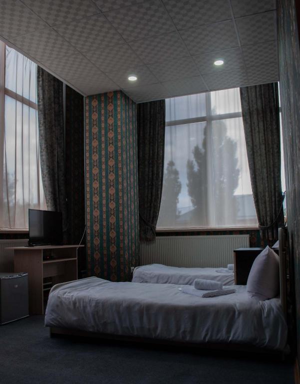 una camera d'albergo con due letti e una finestra di HOTEL SV a Ninotsminda