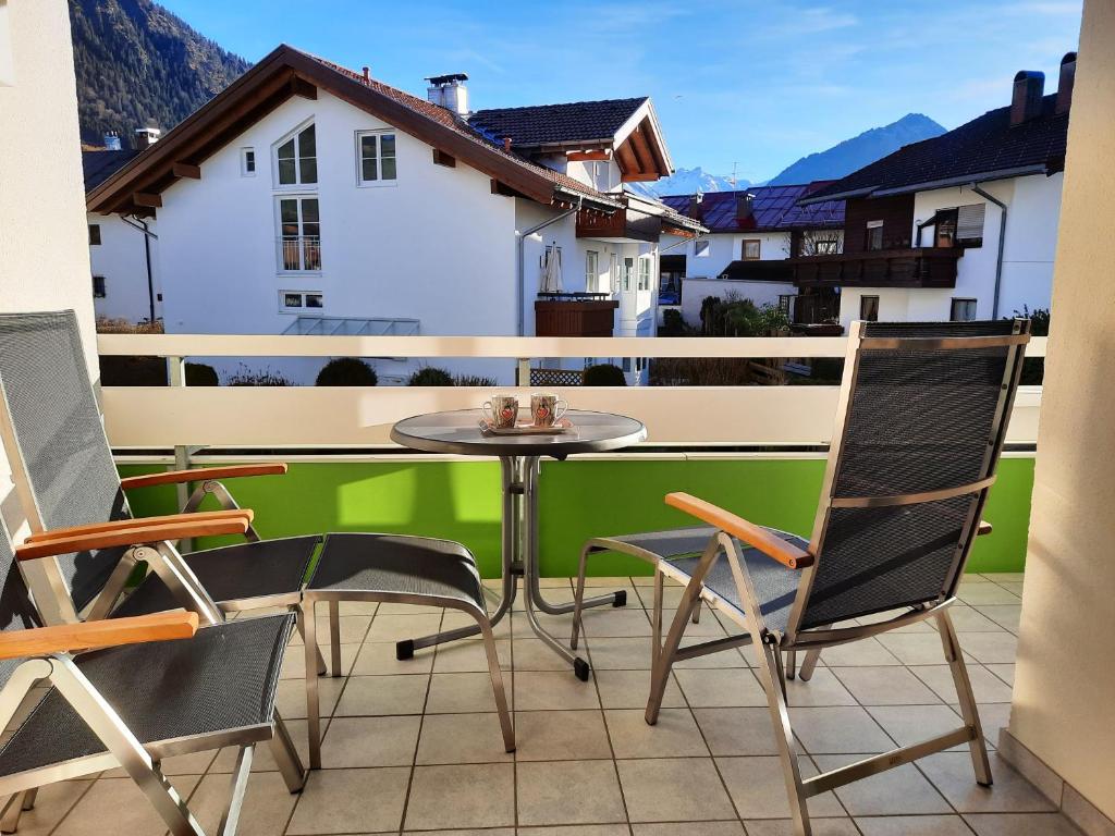 eine Terrasse mit einem Tisch und Stühlen auf dem Balkon in der Unterkunft Alpenflair Ferienwohnungen Whg 301 in Oberstdorf