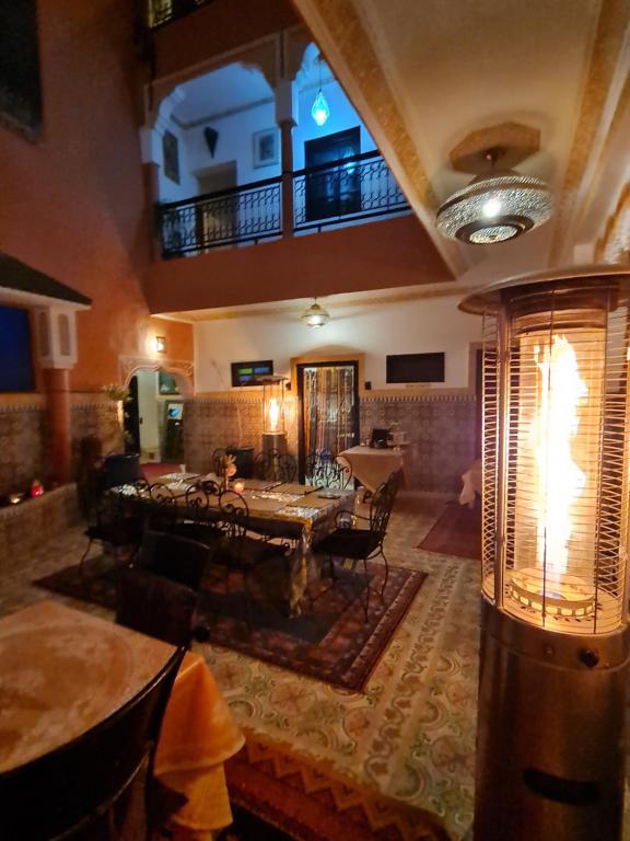 ein Wohnzimmer mit einem Tisch und einem Balkon in der Unterkunft Riad Kanata in Marrakesch