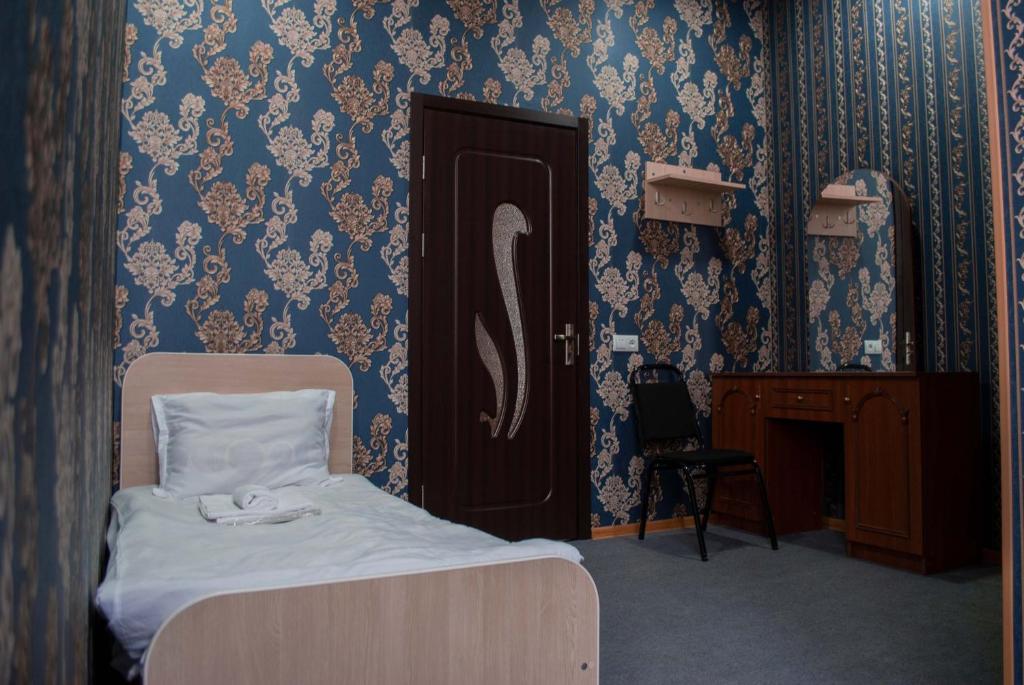 una camera da letto con un letto e una porta con carta da parati di HOTEL SV a Ninotsminda