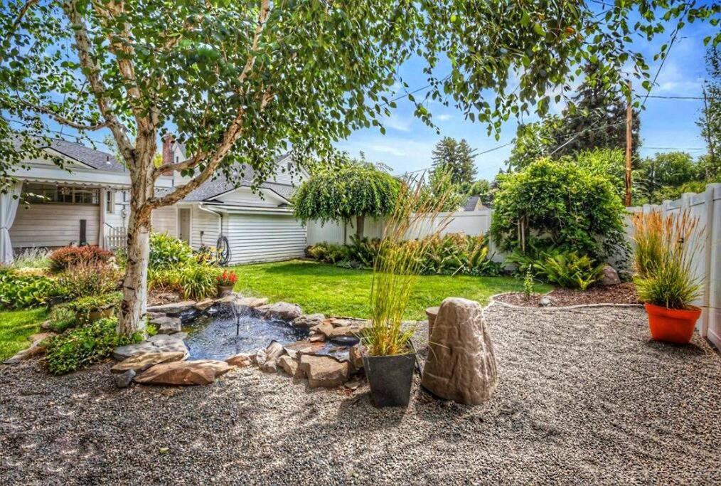 a backyard with a tree and a pond at Centrally located, family and furry friendly fun! in Yakima