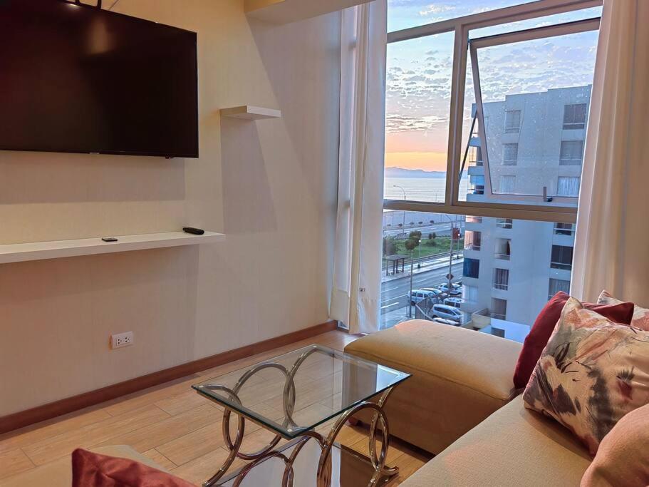 een woonkamer met een bank en een glazen tafel bij Ocean Apartments in Lima