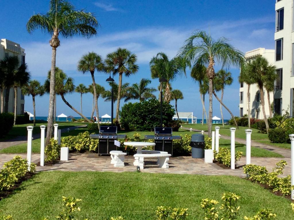 un parc avec des palmiers, une table et des bancs dans l'établissement Island House Beach Resort V17 villa, à Siesta Key