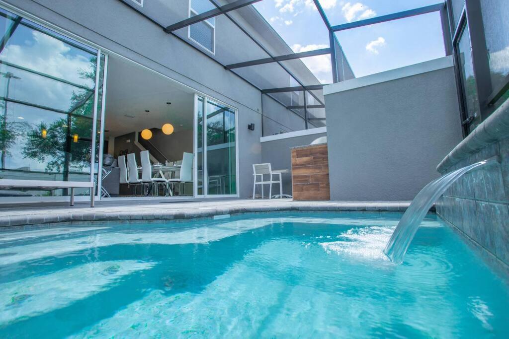 uma piscina com escorrega numa casa em Modern 4 Bedrooms Vacation Home with Splash Pool at Le Reve Resort (4435) em Kissimmee