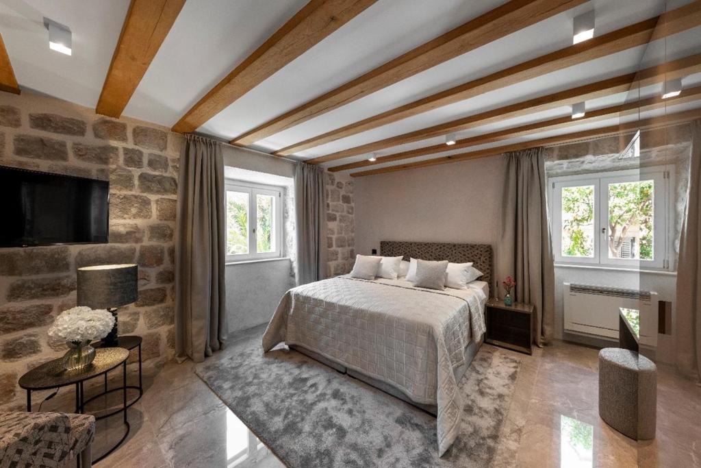 a bedroom with a bed and a stone wall at Sea Rocks Residence in Dubrovnik