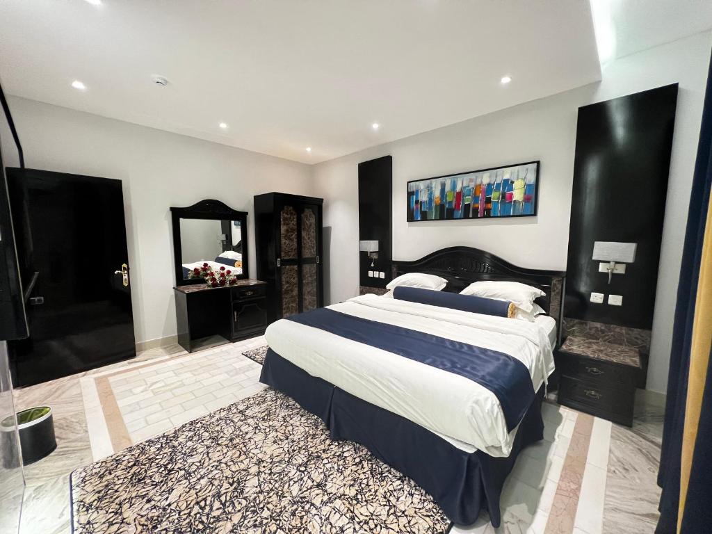1 dormitorio con 1 cama grande y espejo en الذهبية راحتي - golden comfort, en Al Thybiyah