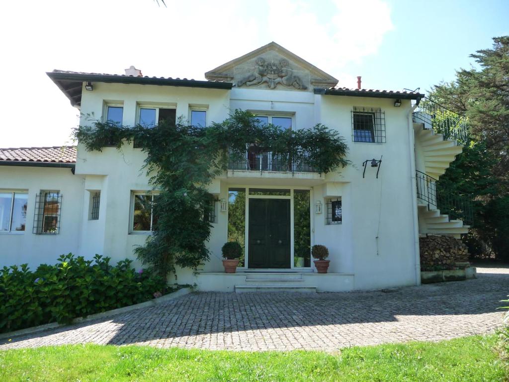 ein weißes Haus mit einer Eingangstür in der Unterkunft Appartement Ranavalo Pays Basque in Anglet