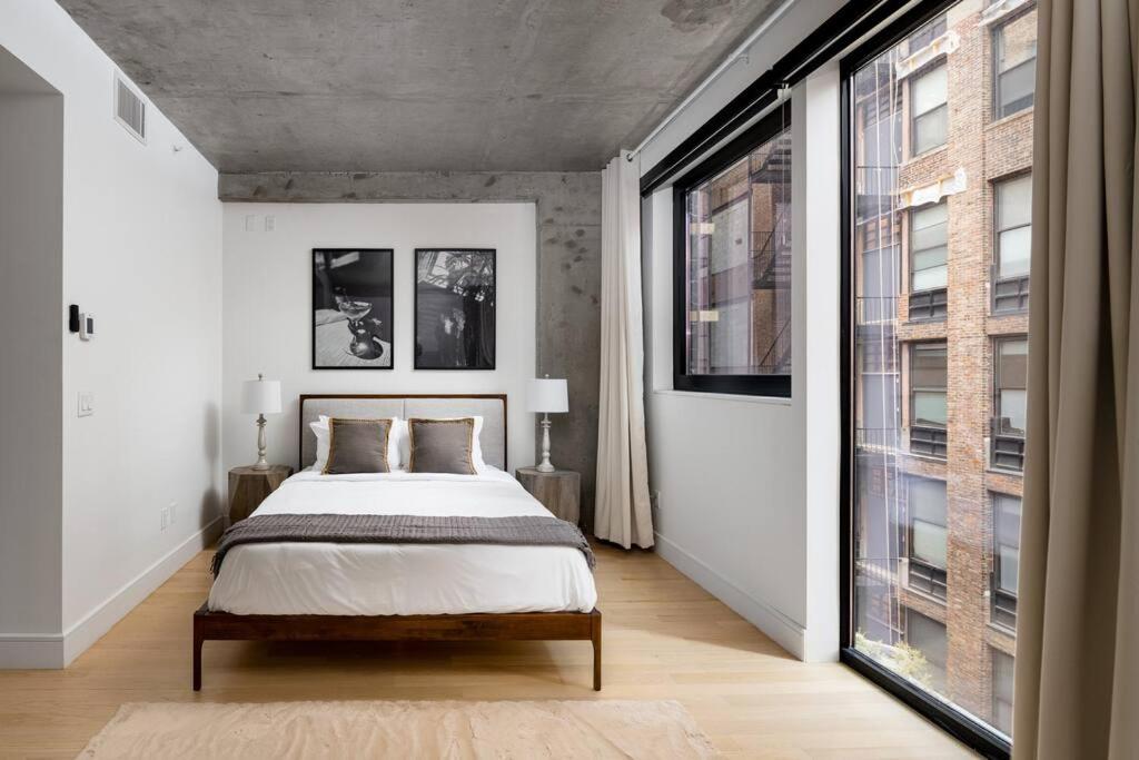 1 dormitorio con cama y ventana grande en Stunning Penthouse in Chelsea en Nueva York