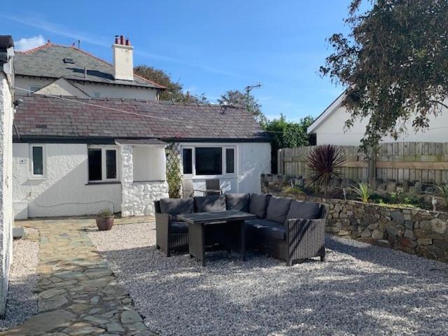 a couch and a table in front of a house at The Wylfa in Abersoch