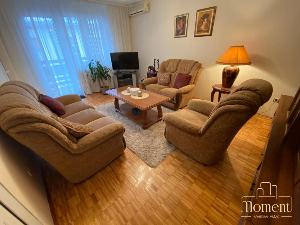 a living room with two couches and a coffee table at Moment Apartman Vrsac in Vršac