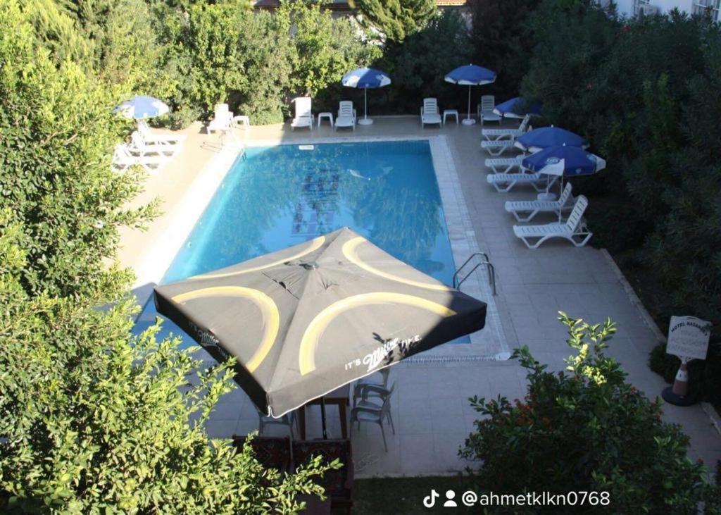 貝萊克的住宿－Hasanbey Apart Otel，享有带遮阳伞和椅子的游泳池的顶部景致