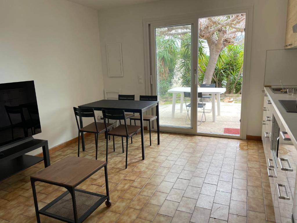 a kitchen with a table and chairs and a table at Vacances entre Bormes et Le Lavandou in Bormes-les-Mimosas