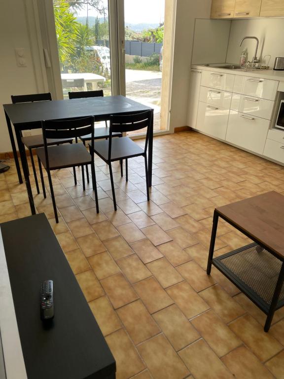 a dining room with a table and chairs and a kitchen at Vacances entre Bormes et Le Lavandou in Bormes-les-Mimosas