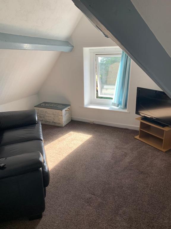a living room with a couch and a window at The Wylfa in Abersoch