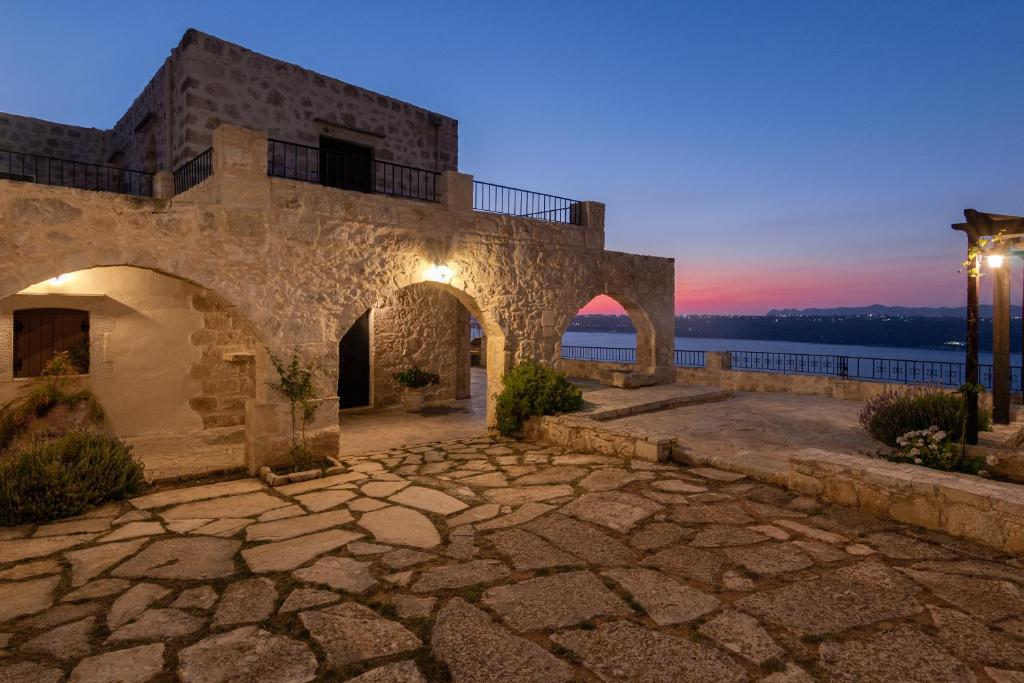 an old stone building with a sunset in the background at Villa Thea in Megála Khoráfia