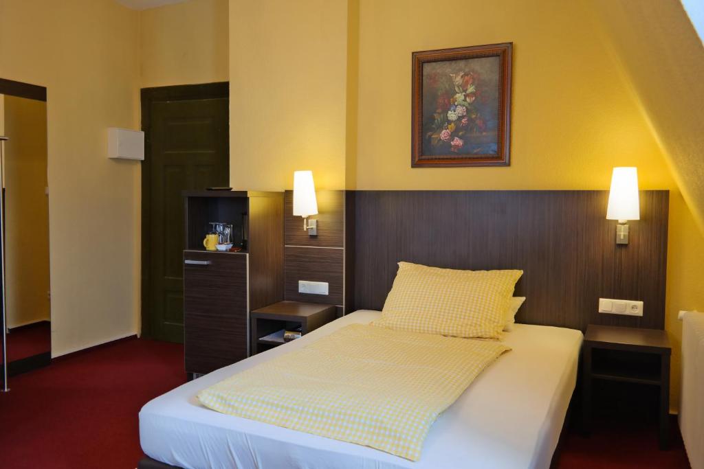 ein Schlafzimmer mit einem Bett mit einem Kopfteil aus Holz in der Unterkunft Hotel Villa Glas in Erlangen