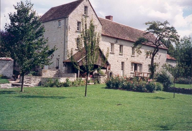 a large white building with a tree in front of it at Moulin de Tingrain 