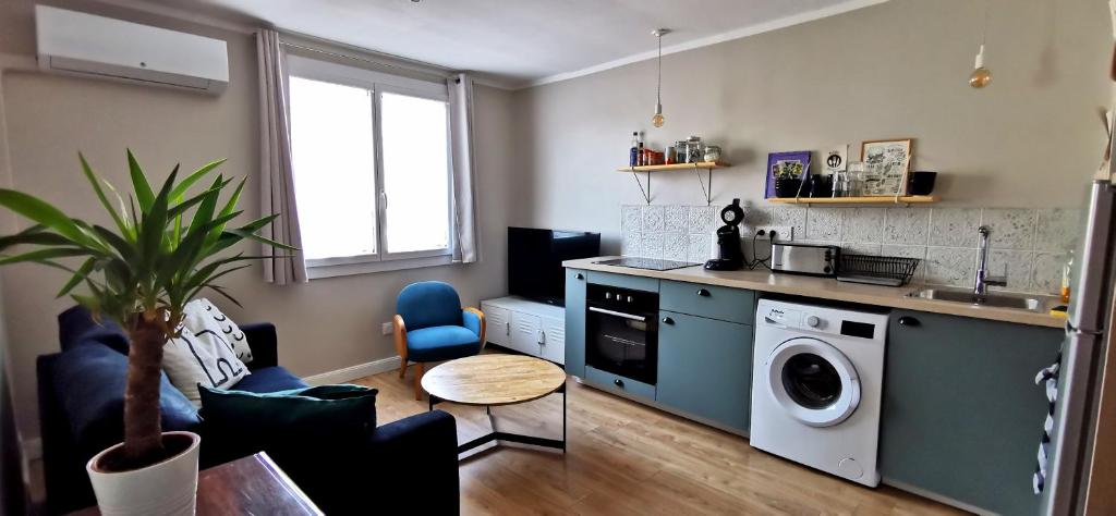 a kitchen with a washing machine and a table at Toulon centre ancien proche gare et départ Corse- 5 pers - FREEWIFI - AC in Toulon