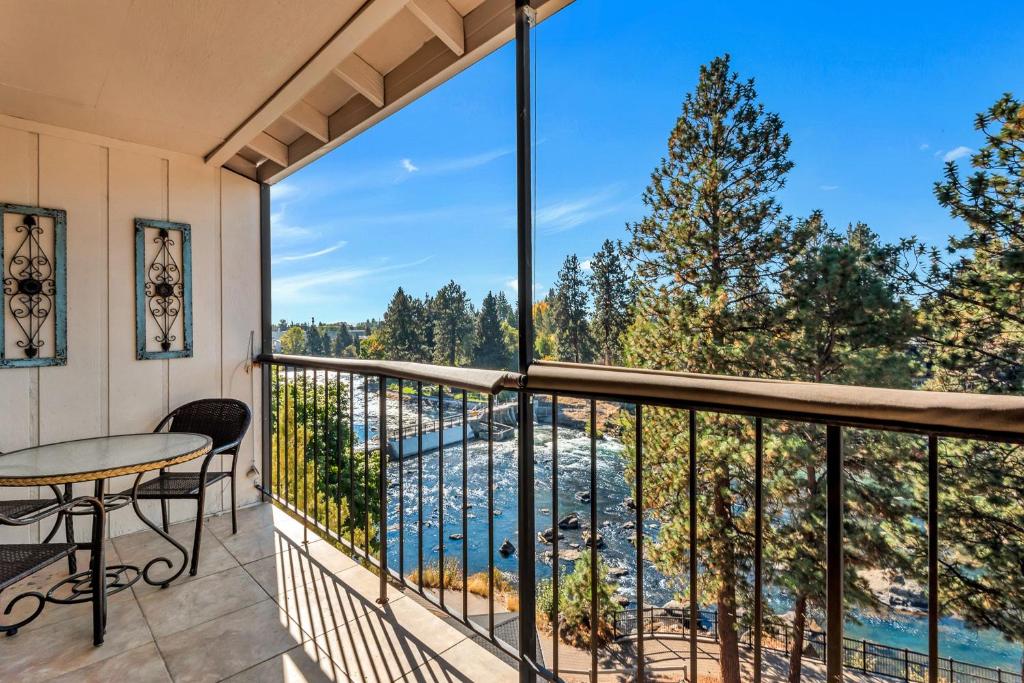 a balcony with a table and chairs and a view at Bend Riverside Condos Near Downtown Bend in Bend