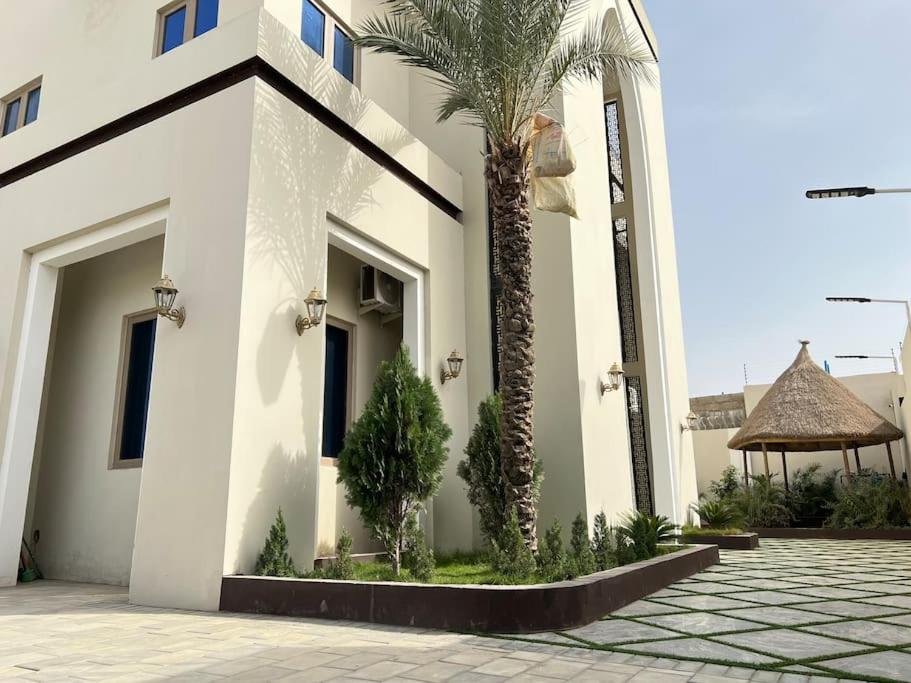 a white building with a palm tree and a gazebo at Exquisite 5 Bedroom Villa in Kano in Kano