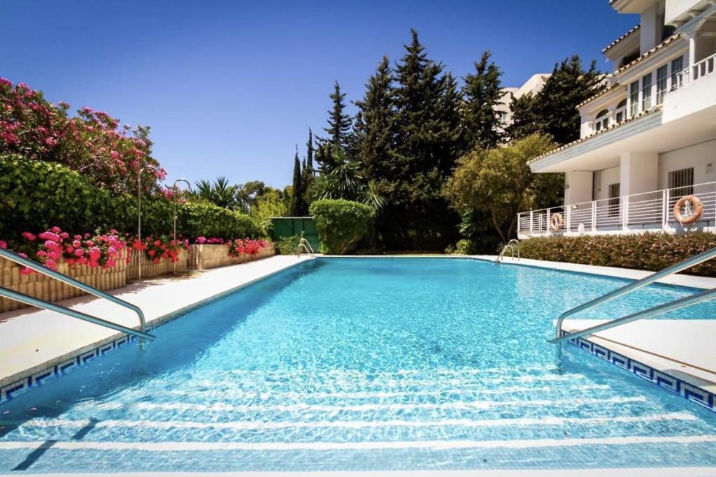 a swimming pool in front of a house at Apartamento Puerto Banus in Marbella