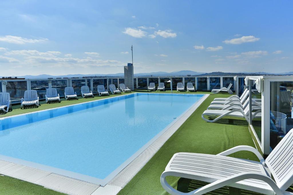 uma piscina no telhado de um edifício com espreguiçadeiras em Hotel Soleblu em Rimini