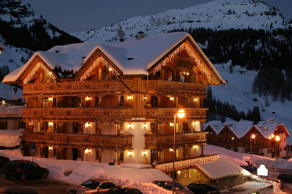 a large building in the snow at night at Chalet Barbara in Arabba