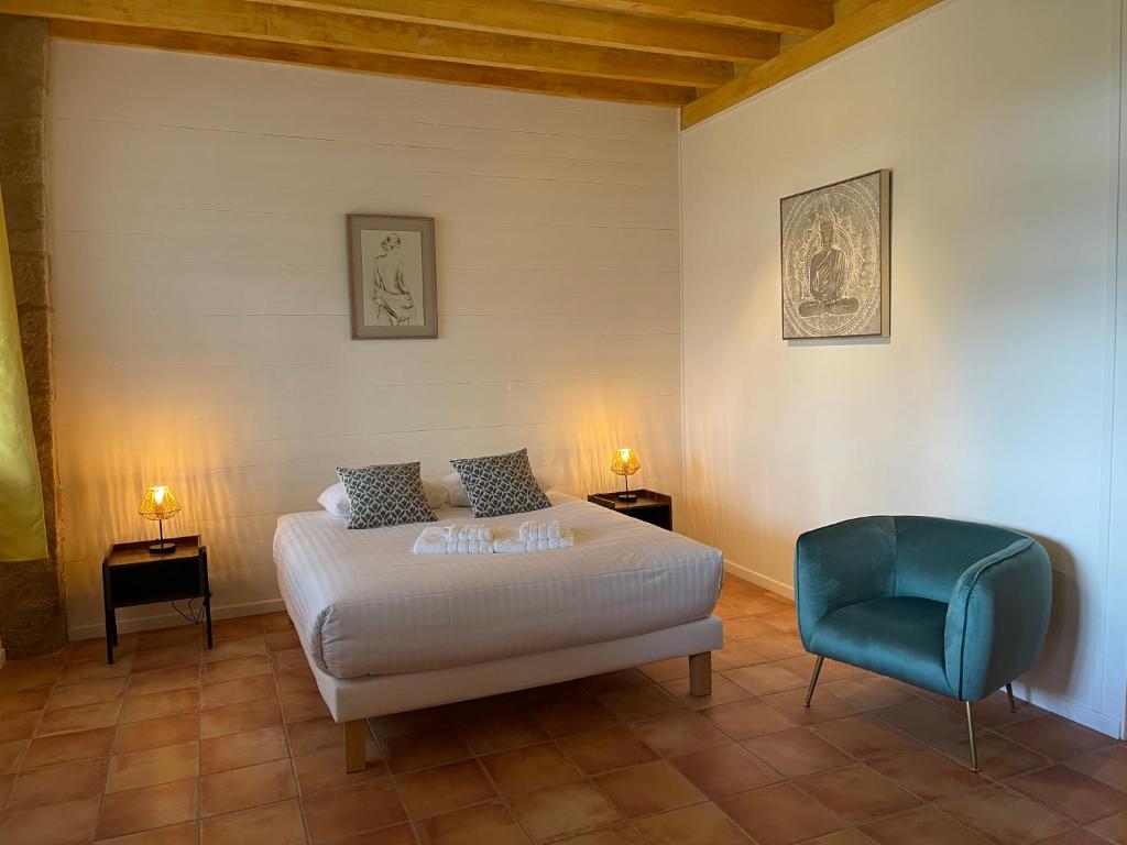 a bedroom with a bed and a blue chair at LAURAGUEL CHAMBRES D'HÔTES in Mourvilles-Hautes