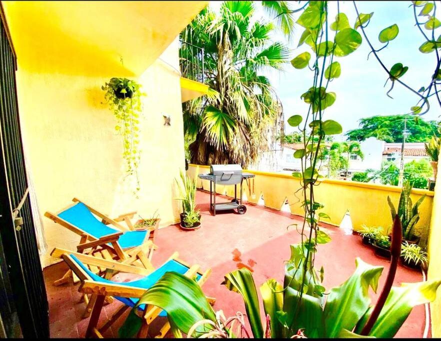 a patio with two chairs and a table and plants at beautiful apartment with the best location in Puerto Vallarta