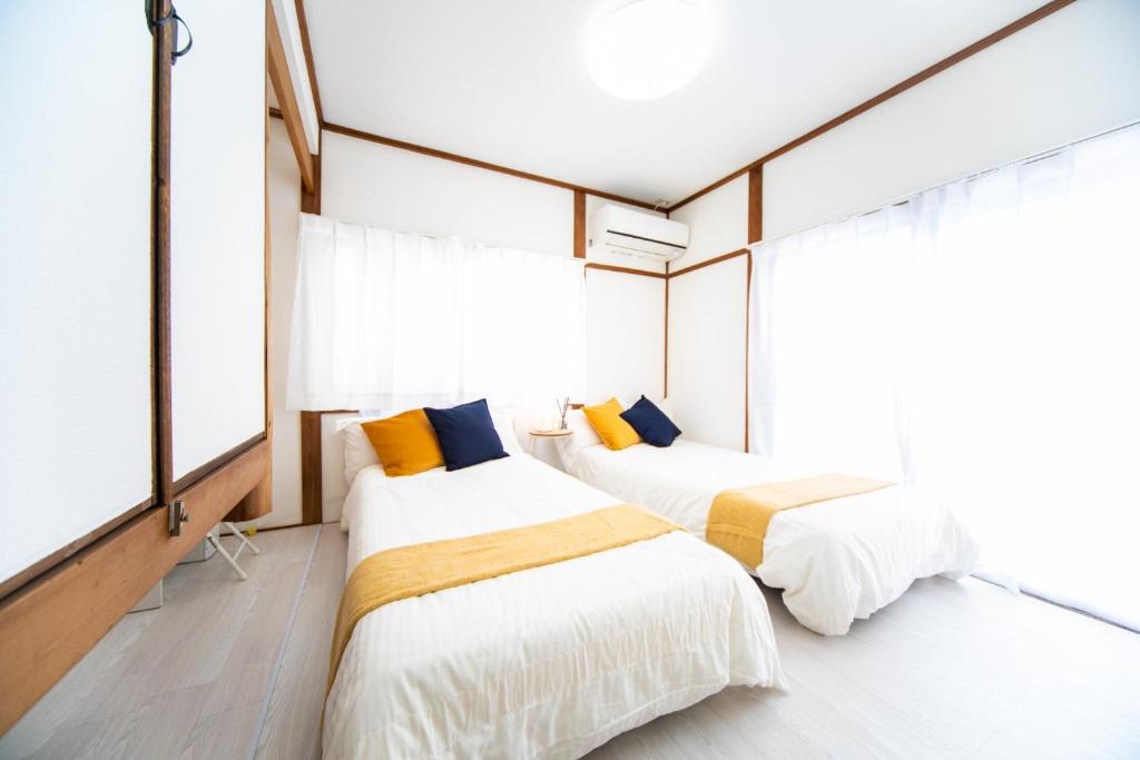 two beds in a room with large windows at Takashima - House - Vacation STAY 68992v in Takashima