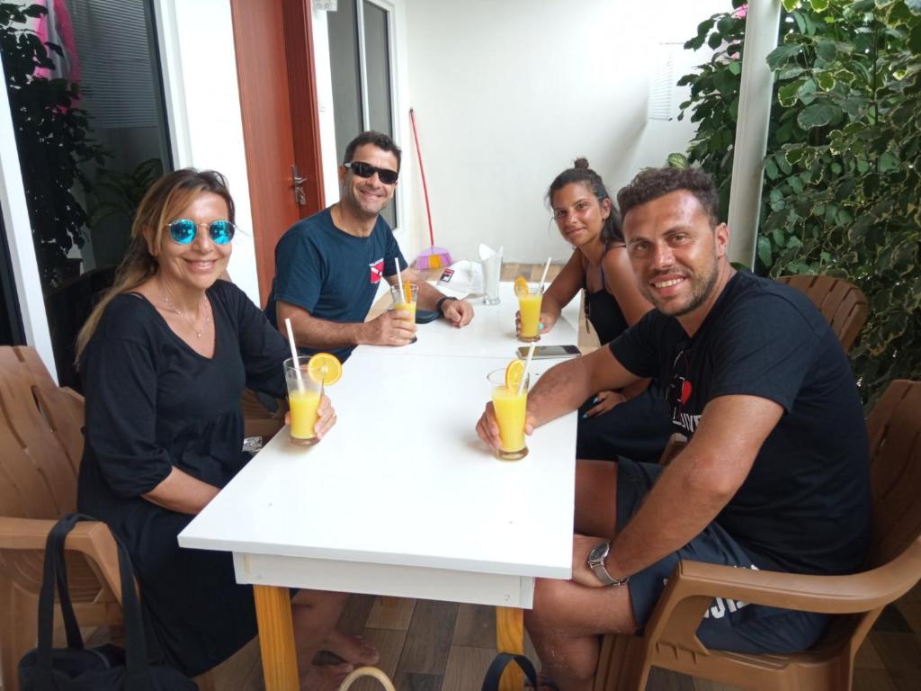 un grupo de personas sentadas alrededor de una mesa con bebidas en Thoddoo Garden inn en Thoddoo