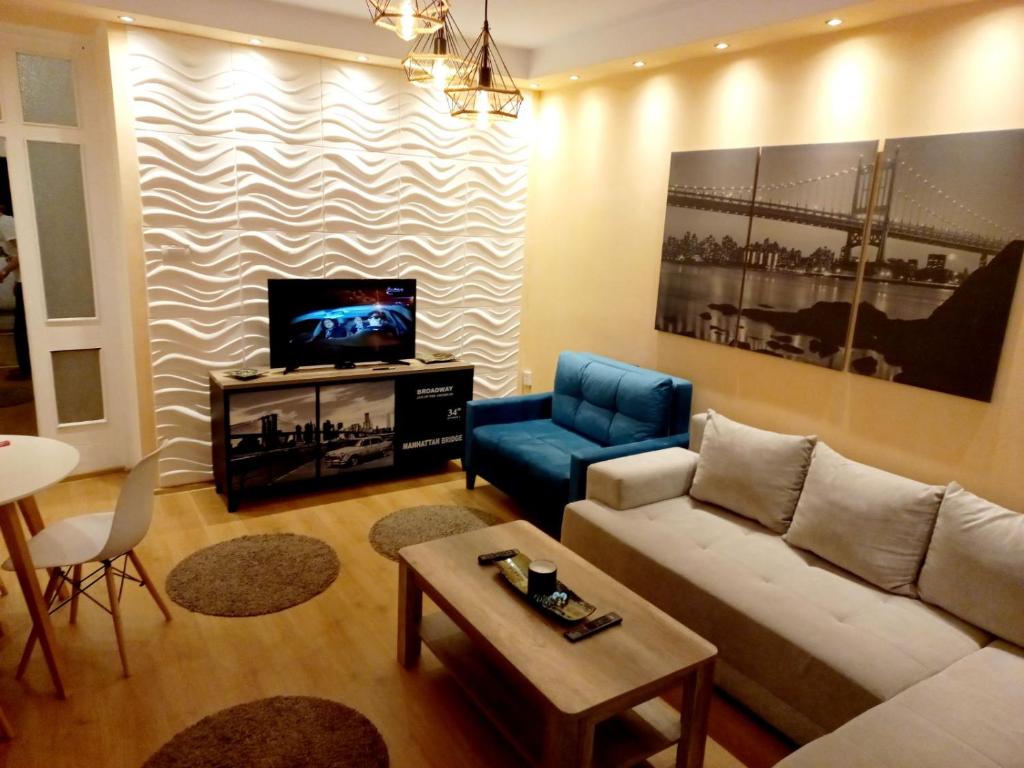 ein Wohnzimmer mit einem Sofa und einem TV in der Unterkunft Apartment Alex 4 in Belgrad