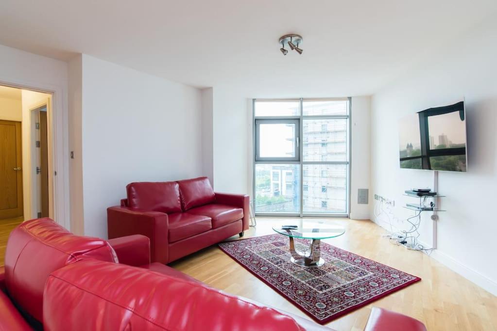 a living room with a red couch and a table at Cardiff City Centre Apartment in Cardiff