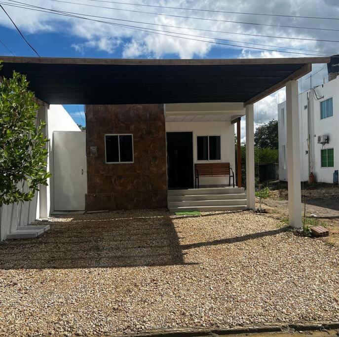Una casa con un porche con un banco. en Cabaña confortable y familiar, en Coveñas
