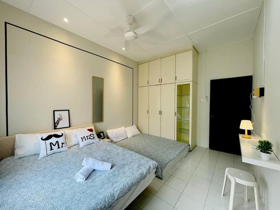 a bedroom with two beds and a chair in it at Ipoh 42 Symphony 12pax 4Bedroom 3bathroom 3carpark in Ipoh
