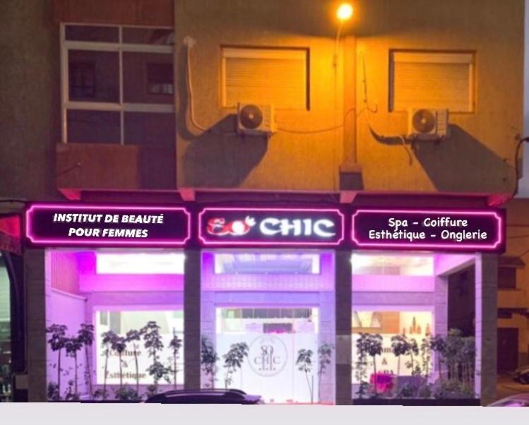 a store with purple lights in front of a building at SO CHIC APPARTEMENT Airport international Rabat-Salé in Salé
