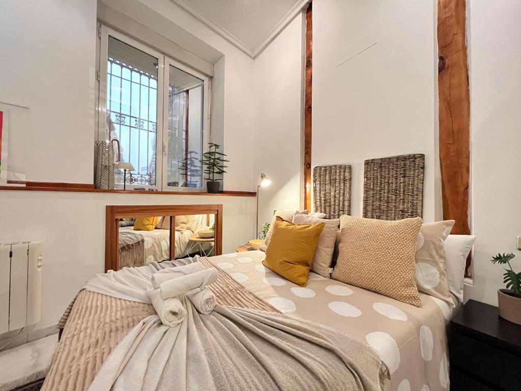 a bedroom with a large bed with pillows at Las Letras Acogedor Huertas San Pedro in Madrid