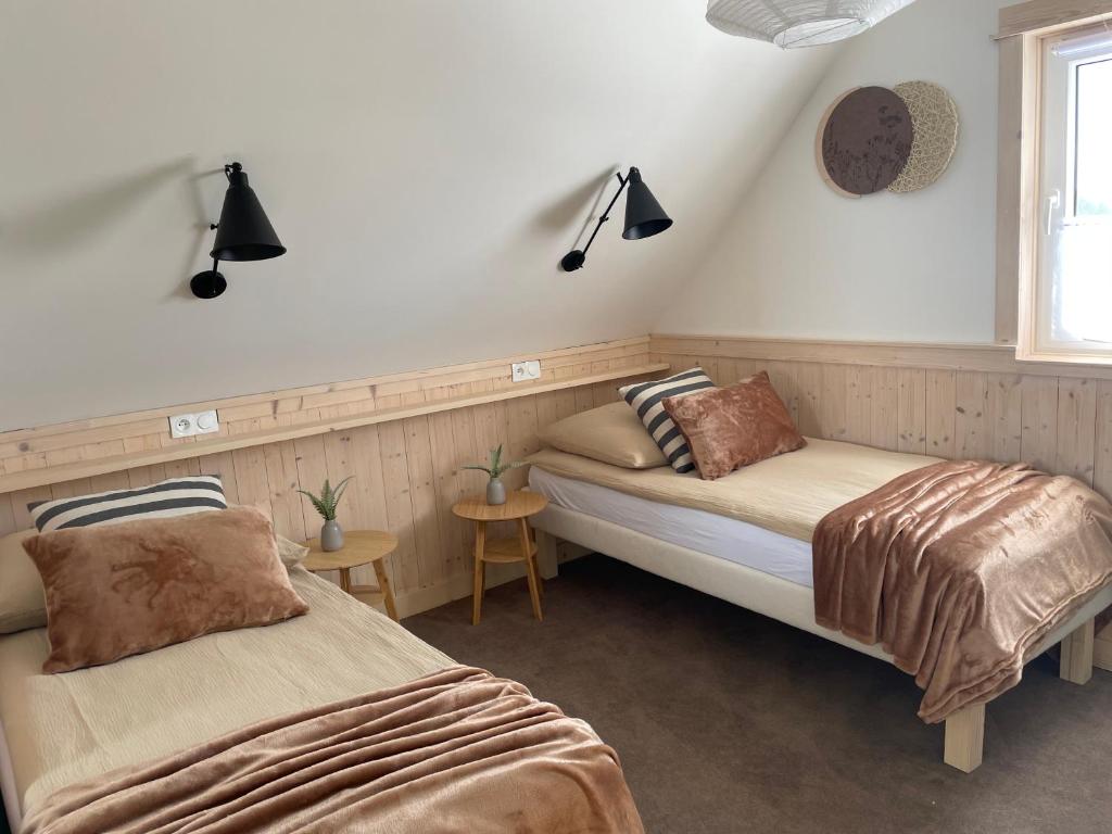 sypialnia z 2 łóżkami i oknem w obiekcie Wioska w Sowich Sokolec w mieście Sokolec
