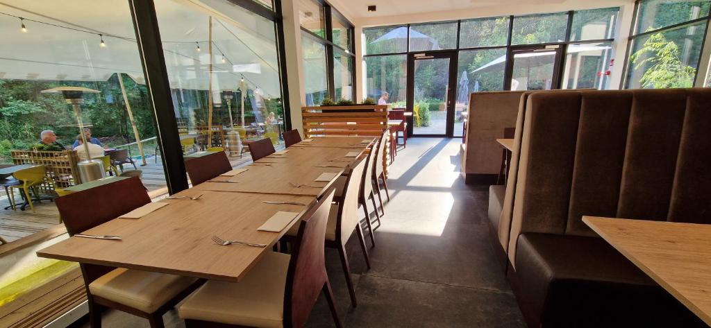 a row of tables in a restaurant with windows at Utopia Hotel - Art & Nature Hotel in Mons
