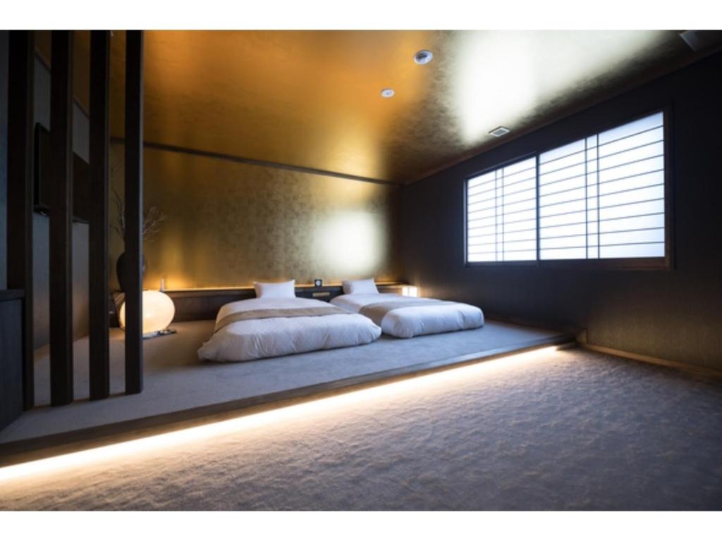 1 dormitorio con 2 camas y ventana en HOTEL SHIKISAI KYOTO - Vacation STAY 74839v, en Kioto