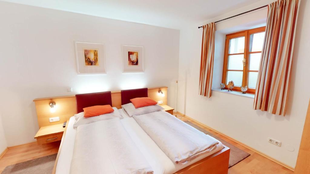 a bedroom with a bed with orange pillows on it at Bauernhofpension Herzog zu Laah in Linz